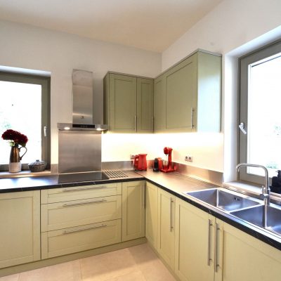 Interior view of Olive Grove villa's kitchen showcasing a sink, stove, and stylish cabinets in a welcoming atmosphere.