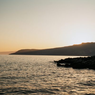 Sunset over the sea and mountains in Kardamyli, Mani, casting warm hues across the landscape.